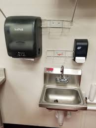 hand sink, paper towel holder and soap