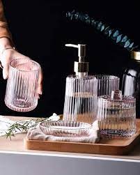 This elegantly designed bathroom set includes an unusual and quite beautiful square soap dish, a liquid soap/lotion dispenser, a toothbrush holder, tissue box cover, a clear glass tumbler in a patterned stand and a wastebasket. 13 Best Bathroom Sets To Buy Online Beautiful Bathroom Accessories