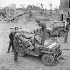 A Casualty On A Stretcher Being Carefully Loaded Onto A Jeep To Be Taken Back To A Regimental Aid Post 3rd Division In Caen Area Jeep Old Jeep Military Jeep