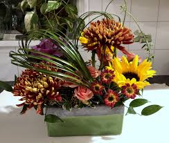 Sunflowers Bronze Gold Chrysanthemums Kale Are Encircled W Molded Bear Grass Funeral Flower Arrangements Fall Flower Arrangements Flower Arrangements