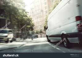 delivery van in the city sponsored ad delivery van city stock photos photo editing city