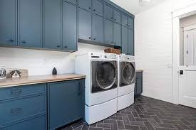 White and blue galley style laundry room featuring stacked washer and dryer, light gray cabinets, and white quartz countertops. Basement Laundry Room Ideas Design Guide Designing Idea