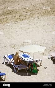 Frau FKK entspannen nackt sitzen auf der Liege am Strand im Urlaub in  Jandia 