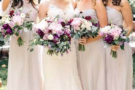 Bride And Her Bridesmaids In Pale Grey Gowns Carry Their Bouquets Of Light Pink Peony Ocean Song Rose Dark Pink Weddings Wedding Flowers Cost Purple Wedding