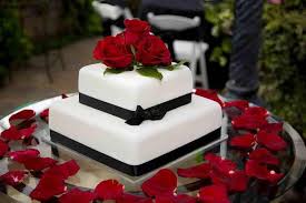 2 Tier Wedding Cake Surrounded By Red Roses And Tied With Black Ribbon Black And White Wedding Cake Wedding Cake Navy Wedding Cake Roses
