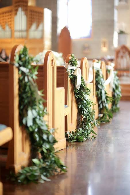 ceremony aisle church pew greenery garland tie