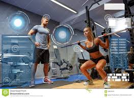 Man And Woman With Bar Flexing Muscles In Gym Stock Image