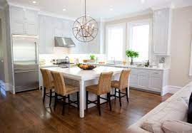 A kitchen with dark hardwood kitchen floor and white cabinets. 30 Kitchen Islands With Tables A Simple But Very Clever Combo