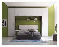 Composizione in stile classico dove un armadio a ponte matrimoniale sovrasta il letto matrimoniale rondine, lasciando che due vani a giorno nelle colonne laterali facciano da comodino. Camere Da Letto Matrimoniali A Ponte Foto Design Mag