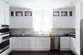 Paired with glossy white subway tile and elegant golden hardware, these cabinets were made to shine. White Kitchen Cabinets With Black Countertops Transitional Kitchen Beth Hale Black Kitchen Countertops Black Countertops Kitchen Cabinets Black And White