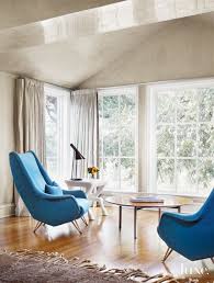 This beautiful accent chair is ideal for compact bedrooms that crave a touch of glam. Modern Neutral Bedroom Sitting Area With Blue Midcentury Chairs Luxe Interiors Design