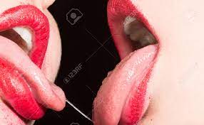 レズビアンのキス。女性同士の情熱。赤い口紅の女性の唇。関係を閉じます。同性愛のセックス。誇り。同性婚。セクシーなキス。唾液で口の中に魅惑的な女性の舌。 ディープ・キス。の写真素材・画像素材 Image 131766435