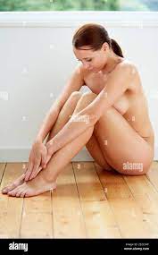 Beautiful naked woman sat on the floor Stock Photo - Alamy