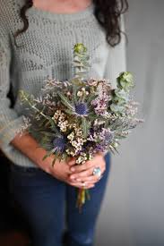 Blue jumbo hydrangea, blue nigella, green eryngium thistle, green astrantia, white camellias, white garden roses, white freesia, & greenery/foliage>>>> winter wedding bouquet with muted green and dusky pinks and purples. Seaside Wildflower Wedding Bouquet Featuring Statice Wax Flowers Thistle And Eucalyptus Thistle Wedding Flowers Thistle Bouquet Wedding Coral Wedding Flowers