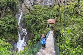 A volcano, spas, and sights from pailon del diablo waterfall to termas de la virgen—discover it all in baños de agua plaza isidro ayora 100, baños de agua santa, tungurahua. Ecuador Tungurahua Banos De Agua Santa Tourists Standing On Bridge Near Waterfall Pailon Del Diablo View Colors Stock Photo 180095936