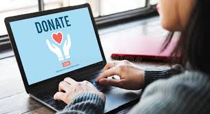 Woman using laptop on which the screen says donate