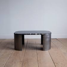 This space proves that a minimalist table goes well with minimal, flowery styling. Minimalist Steel And Stone Coffee Table Lawton Mull