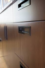 The gloss and lightness of the cabinets match the polished porcelain tile flooring but contrast with the matte grey walls and grey curtain over the wash. Modern Cabinet Hardware Doorware Com