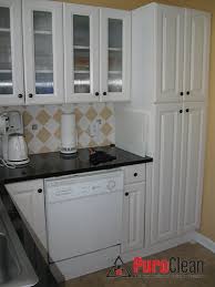 In this kitchen, the few upper cabinets are shrouded in white, camouflaged against the white wall, while the dark gray base cabinets balance the matching range hood. The Most Common Cause Of Kitchen Mold And What To Do About It