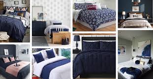 Navy blue wooden bed with a rope nightstand styled with a white lamp in a beige and blue boys cottage bedroom finished with vertical plank walls. 16 Best Navy Blue Bedroom Decor Ideas For A Timeless Makeover In 2021
