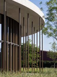 Slender Metal Columns Support The Concrete Roof Of This Cylindrical Headquarters By Local Architecture For The I Circular Buildings Round Building Architecture