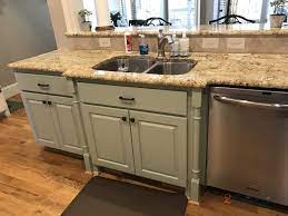 Break up an all white kitchen by adding color to your cabinets. Clary Sage Island 2 Cabinet Girls