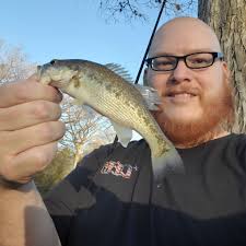 An angler poses outside the San Antonio Light Building with a 48-pound  catfish that he caught at the Medina. 1910