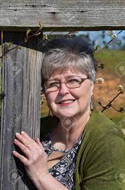 Next Door Neighbor Peeks Through The Hole In The Fence. She Is Wearing  Glasses And Is An Older Mature Woman. Stock Photo, Picture and Royalty Free  Image. Image 147143067.