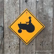 Black And Yellow Sign On Road A Tractor Highway Road Sign In Black On Yellow In Rural Farming Areas You Will See Signs Like These On Highways A Road Signs Funny Road Signs Screen Printing