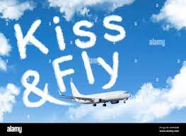 Kiss and fly an inscription in the sky left by airplanes, the concept of  departure in travel Stock Photo - Alamy