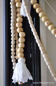 How To Make Wood Bead Garland With Yarn Tassels Wood Bead Garland Wood Beads Wooden Bead Garland