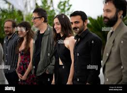 Deniz Celiloglu, from left, Ece Bagcı, director Nuri Bilge Ceylan, Merve  Dizdar, Musab Ekici, and Erdem Senocak pose for photographers at the photo  call for the film About Dry Grasses at the
