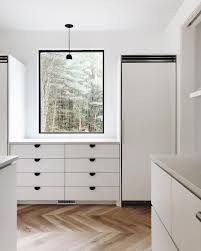 The backs of the open shelves and glass door upper cabinets help add interest with a pop of vintage blue that highlights the servingware. White Cabinet Black Kitchen Handles Novocom Top