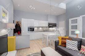 In the sitting space, get a vibrant carpet and place a round glass table in the middle, with furniture around. Open Plan Apartment With Living Room Kitchen And Dining Table With Chairs In One Room Stock Photo Picture And Royalty Free Image Image 148906705