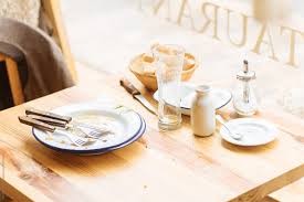 The number of tables in use has decreased by as tables emptied. Empty Plates Left On Cafe Table After Meal By Pietro Karras Stocksy United
