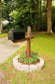 Pflegeleichtes Beet Voller Roten Und Lila Blumen Um Dem Briefkasten Von Steinen Umgeben Mailbox Landscaping Mailbox Garden Mailbox Flowers