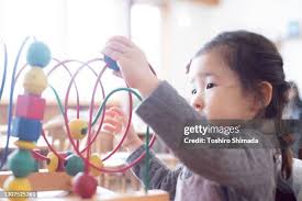 A Female Child Playing With Wooden Toy High-Res Stock Photo