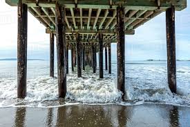 As for size, you'll discover quaint beach cottages, towering waterfront mansions, and everything in between in the collection below. Waves Splashing On Pilings Of Wooden Pier At Beach Stock Photo Dissolve