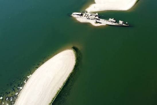 Aerial view of the low water levels on the Danube River with industrial barges grounded due to historic drought.