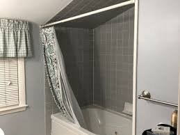 Black subway tiles in a transitional walk in shower featuring a white drop in tub, a sloped shower ceiling and a frameless glass enclosure. Sloped Ceiling Over Bathtub