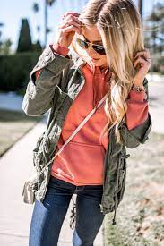 The California Winter Uniform Military Jacket Over Coral Sweatshirt Jeans Velvet Sneakers Green Sweatshirt Outfit Coral Outfit Casual Style Outfits