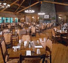 With its large stone fireplace adorned with an original painting of the geyser basin, the old faithful inn's dining room, seats 300 and offers a kids' menu at all meals. Old Faithful Inn Dining Room Original Old Hickory Chairs Yellowstone Vacation Cabin Design Rustic Cabin Decor