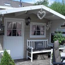 Ein Gemutliches Gartenhaus In Grau Und Weiss Mit Kuschelige Terrase Und Eine Bank Fur Die Sitzung In Die Schonen Abende Bekomm Garten Gartenhaus Cottage Garten