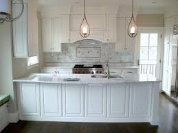 Mounted to marble mini brick backsplash tiles, a black range hood accented with brass. Arlington Remodel White Raised Panel Full Overlay American Traditional Kitchen Dc Metro By St Clair Kitchens Houzz