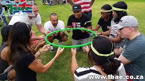 Hold hands and step through a hula hoop to pass it down the line before the other team does! Hula Hoop Down Team Building Exercise