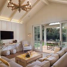 A modestly sized living room with a traditionally patterned area rug and a large cherry wood coffee table between the sofa and loveseat. Mediterranean Living Room Cathedral Ceiling Design Ideas