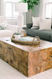 An Oval Rope Tray Accents A Wood Block Coffee Table Positioned On A White Grid Rug In Front Of A Living Room Coffee Table Coffee Table Coffee Table Decor Tray