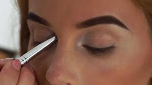 woman face while applying eyes makeup