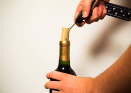 She's holding a wine opener without knowing it or making a joke that she doesn't know it. 7 Genius Ways To Open A Wine Bottle Without A Corkscrew