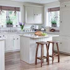 If you're looking to add some cozy farmhouse style to your small kitchen, this might be the perfect design for you. Love This Small White Cottage Farmhouse Kitchen The Gray Countertops Give A Little Offset Small Cottage Kitchen Small Country Kitchens Cottage Style Kitchen